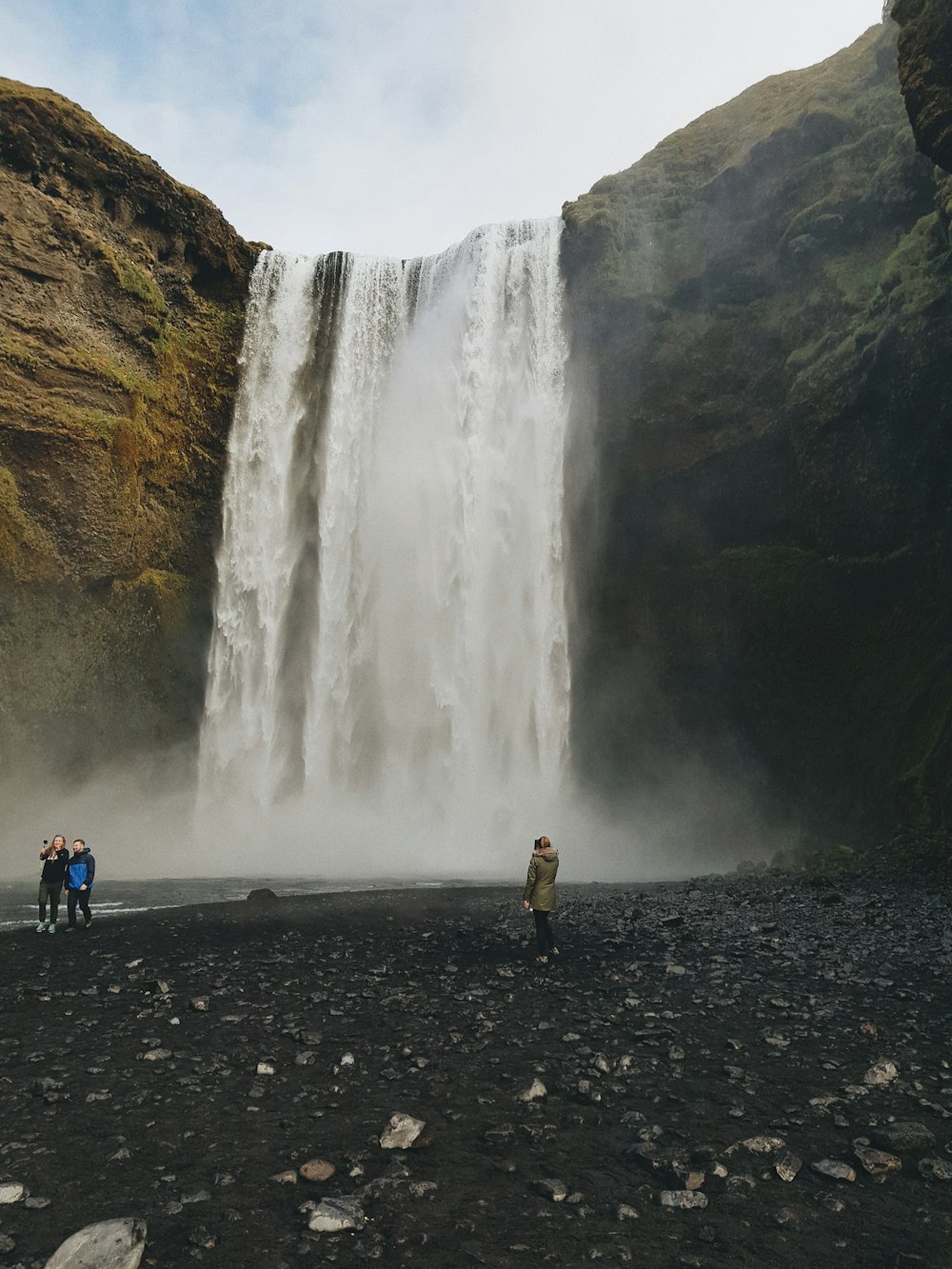 people standing near waterfalls during daytime