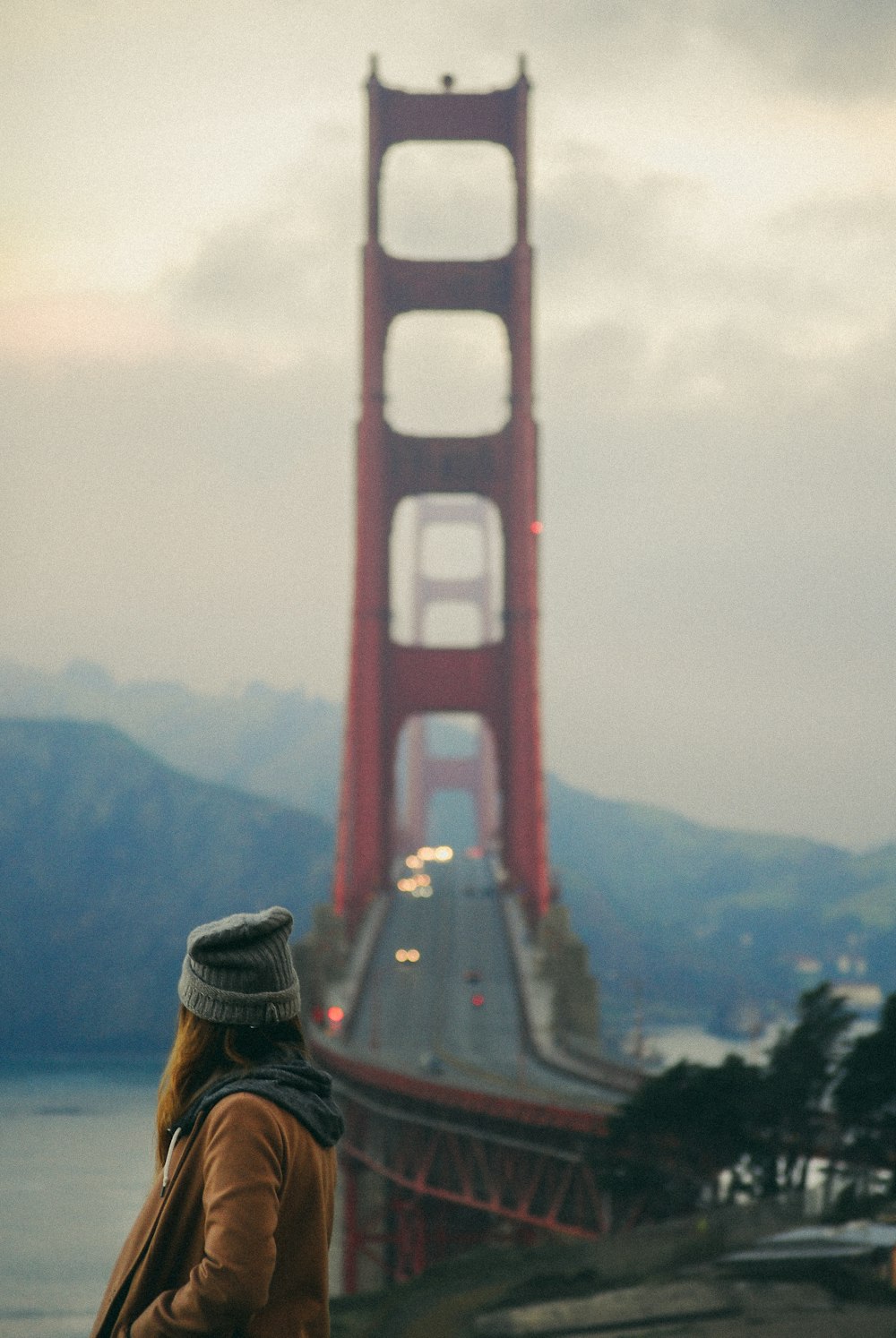 Frau mit grauer Mütze starrt auf die Golden Gate Bridge