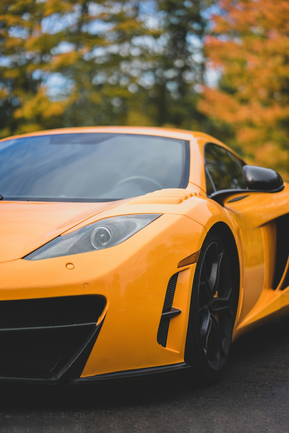 orange sports car near trees