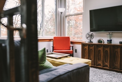 A cozy recliner chair positioned next to a stylish TV unit in a warm living space.