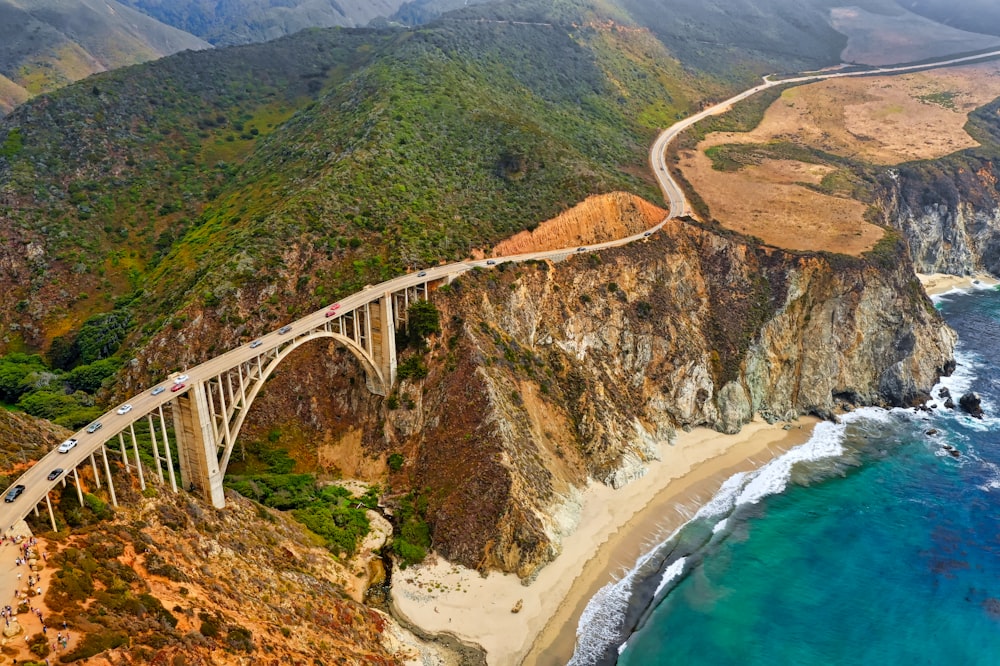 Vista aérea de veículos na ponte cinza perto do oceano