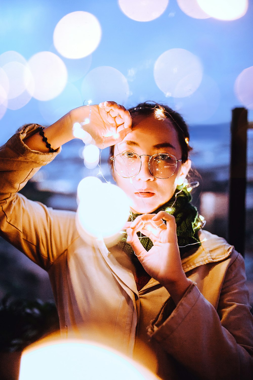 Photographie de mise au point sélective d’une femme tenant des guirlandes lumineuses