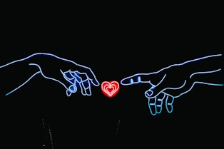 neon light photo of two hands touching red heart