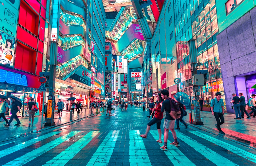 people walking on road near well-lit buildings