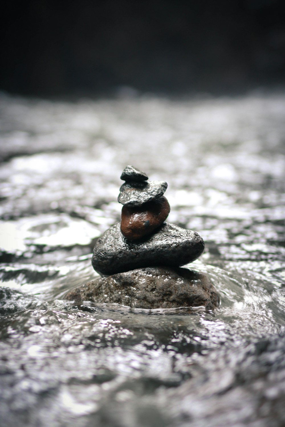 close-up photo of stones on top of each other surrounded by water