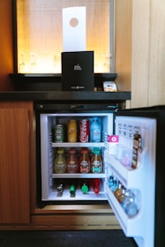 open black compact refrigerator filled with soda bottles