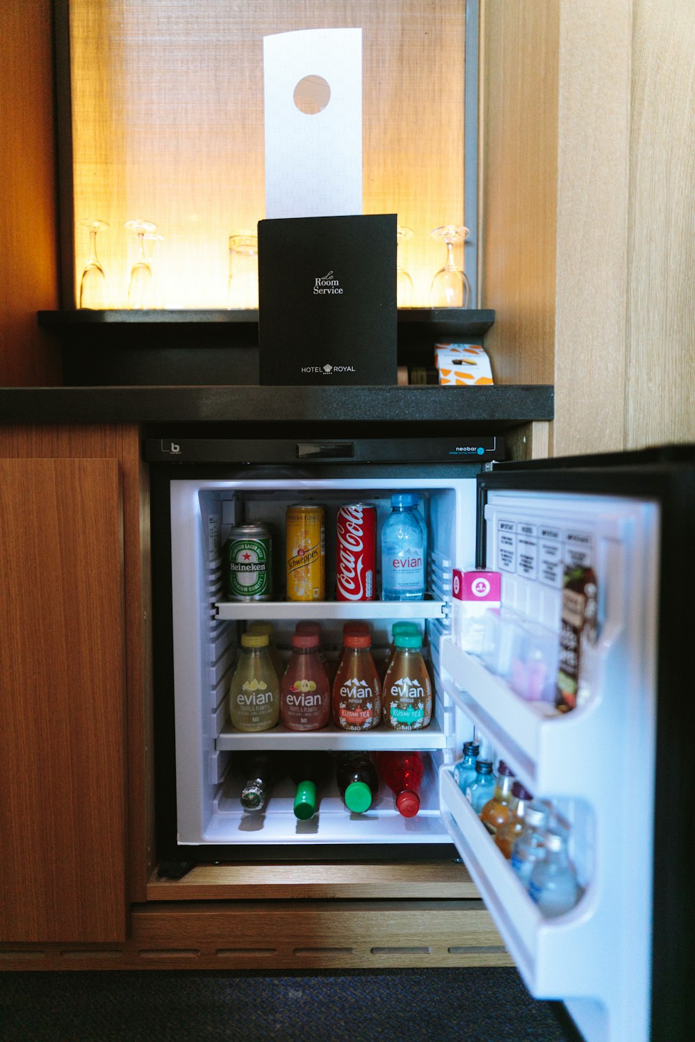 Offener schwarzer Kompaktkühlschrank gefüllt mit Limonadenflaschen