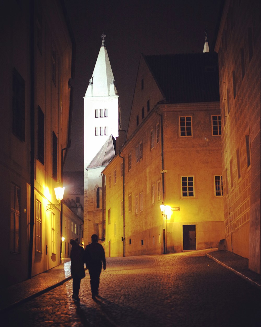 two people walking on alley during night time