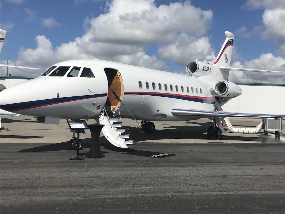 aereo di linea bianco su marciapiede grigio