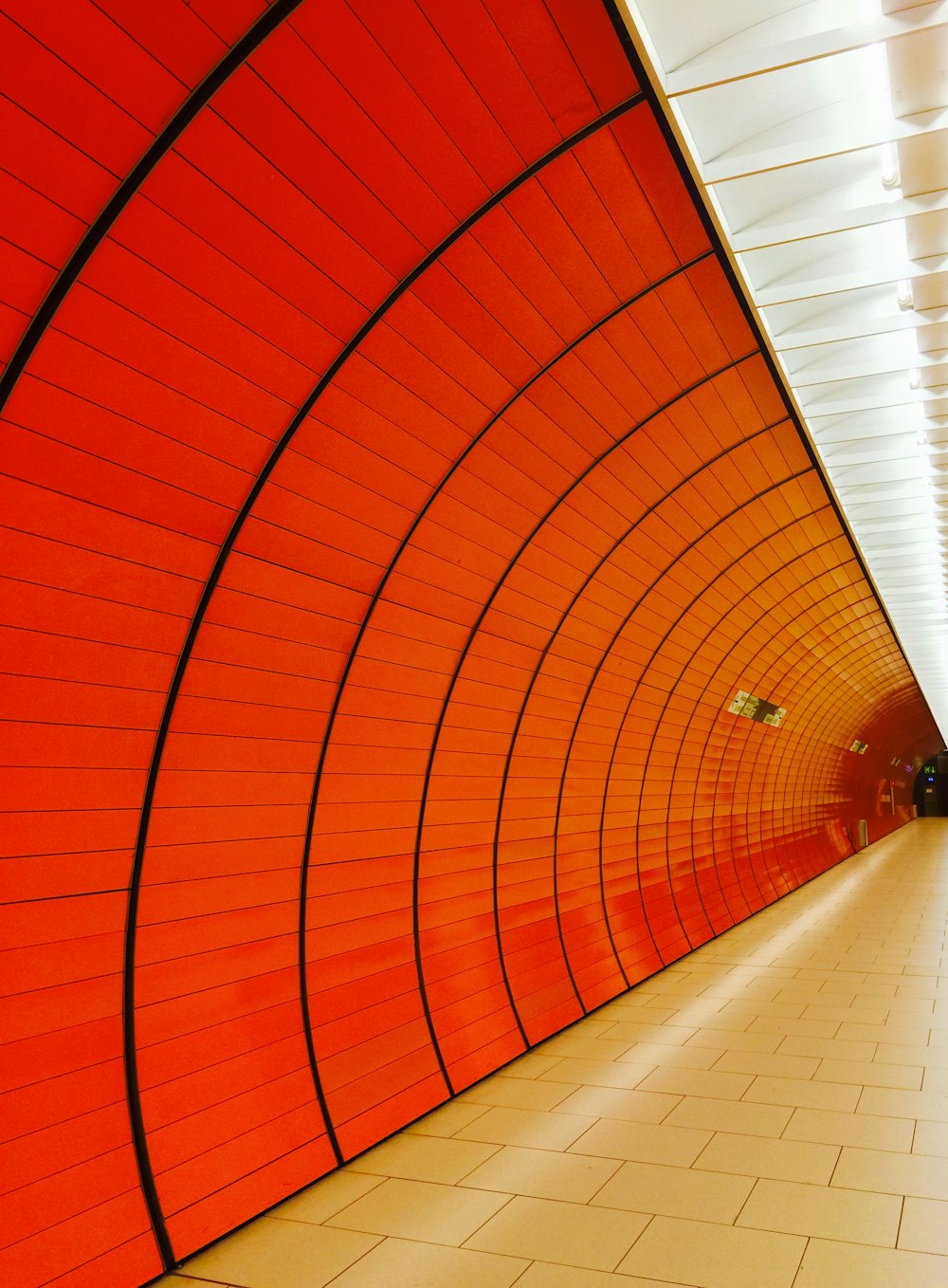 a red and white tunnel with a clock on the wall