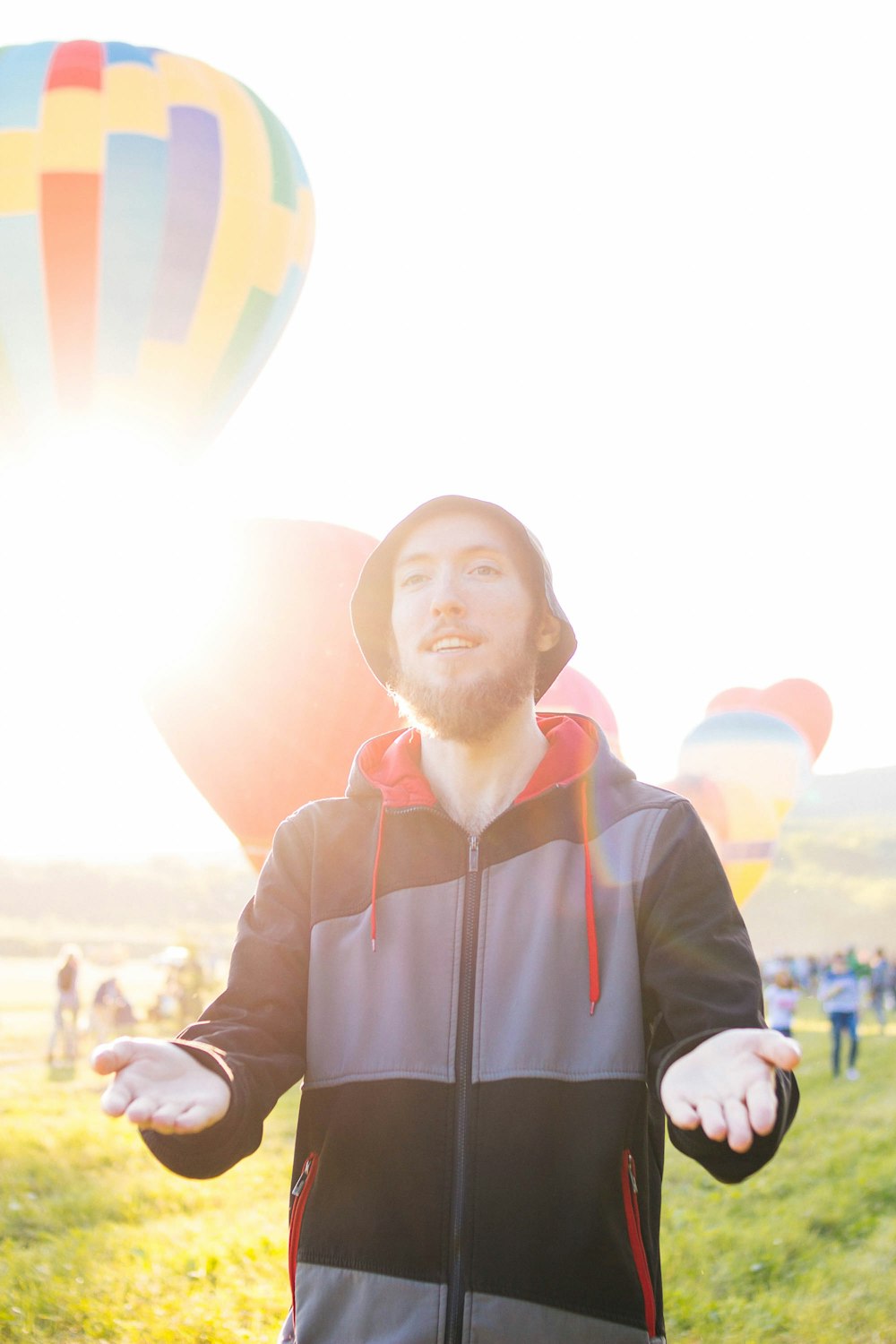 Mann mit Pullover-Kapuzenpullover, der in der Nähe von Heißluftballons steht