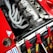 A detailed view of a high-performance car engine with multiple exhaust pipes and various mechanical components. Red safety harnesses are visible, hinting at a racing environment. The engine is housed in a red car with various decals and markings.