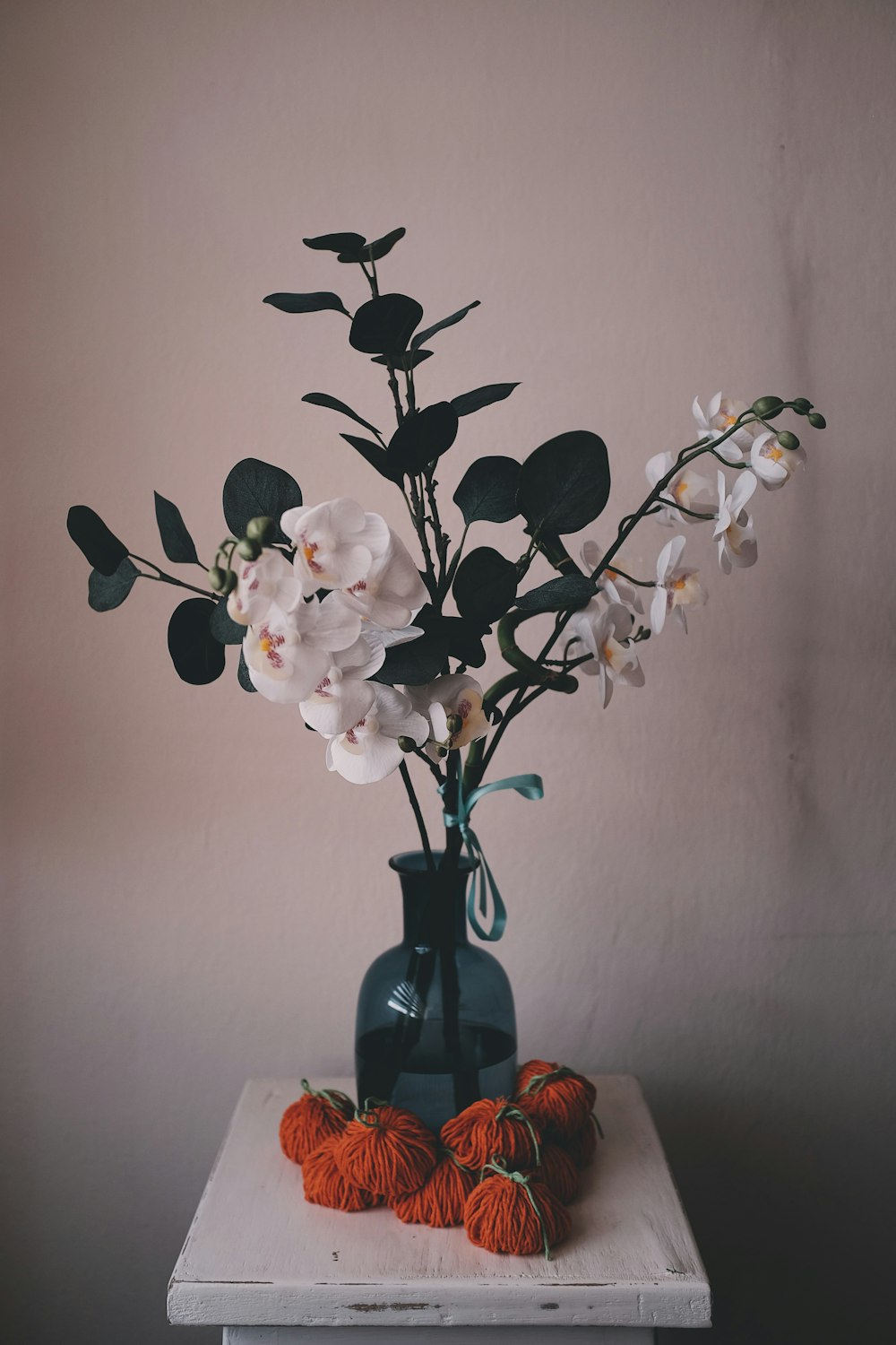 white flower bouquet inside blue glass vase