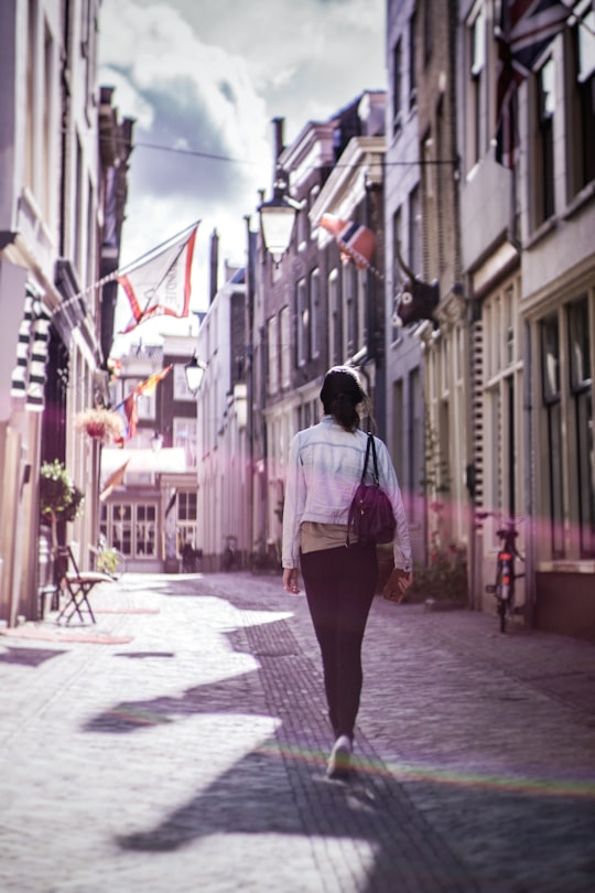 woman walking along buildings in Dordrecht Netherlands