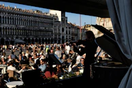 Street musicians performing in a bustling square embraced by Baroque architecture.