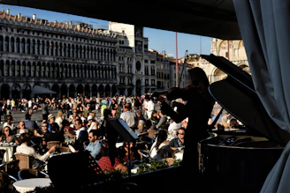 A lively orchestra performing outdoors in a charming town square during sunset.