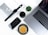 A neatly arranged flat lay featuring modern tech gadgets and accessories. Items include a MacBook, iPhone, Apple Watch, AirPods, a camera lens, a small succulent plant, and a cup of coffee placed on a clean white desk surface alongside a stylish magazine.