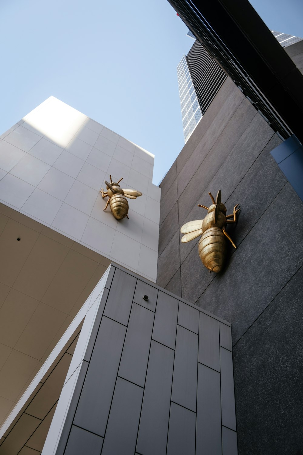 회색 콘크리트 건물에 회색 꿀벌 조각상