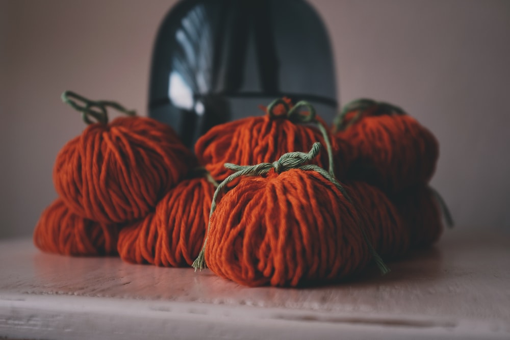 orange yarns on white surface