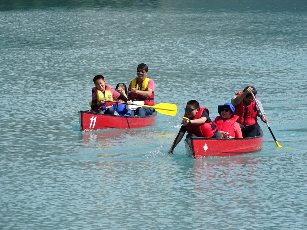 people riding on red canoe