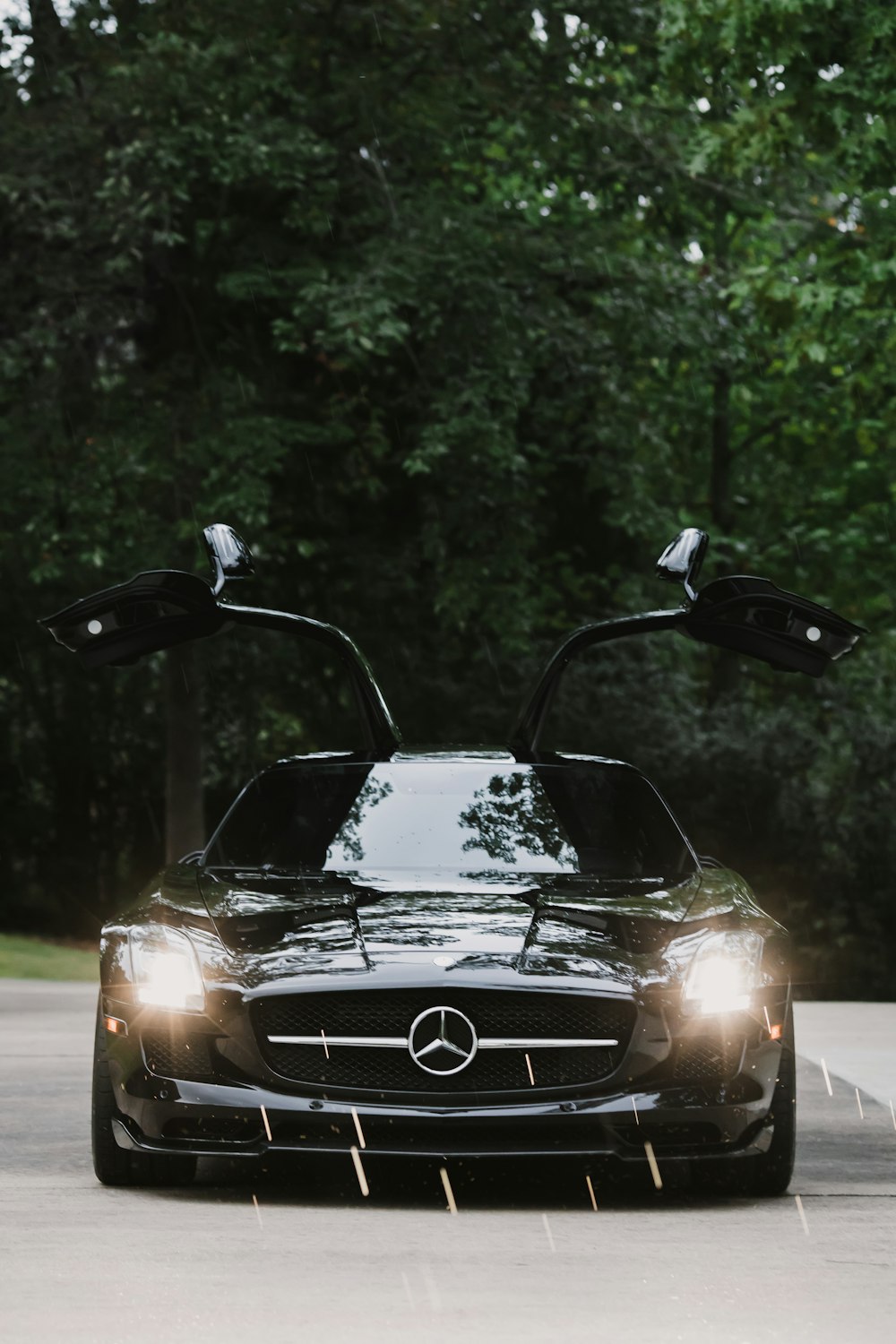 open door and turned-on headlights of black Mercedes-Benz coupe