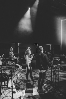 Musicians performing on stage with visible audio equipment and cables