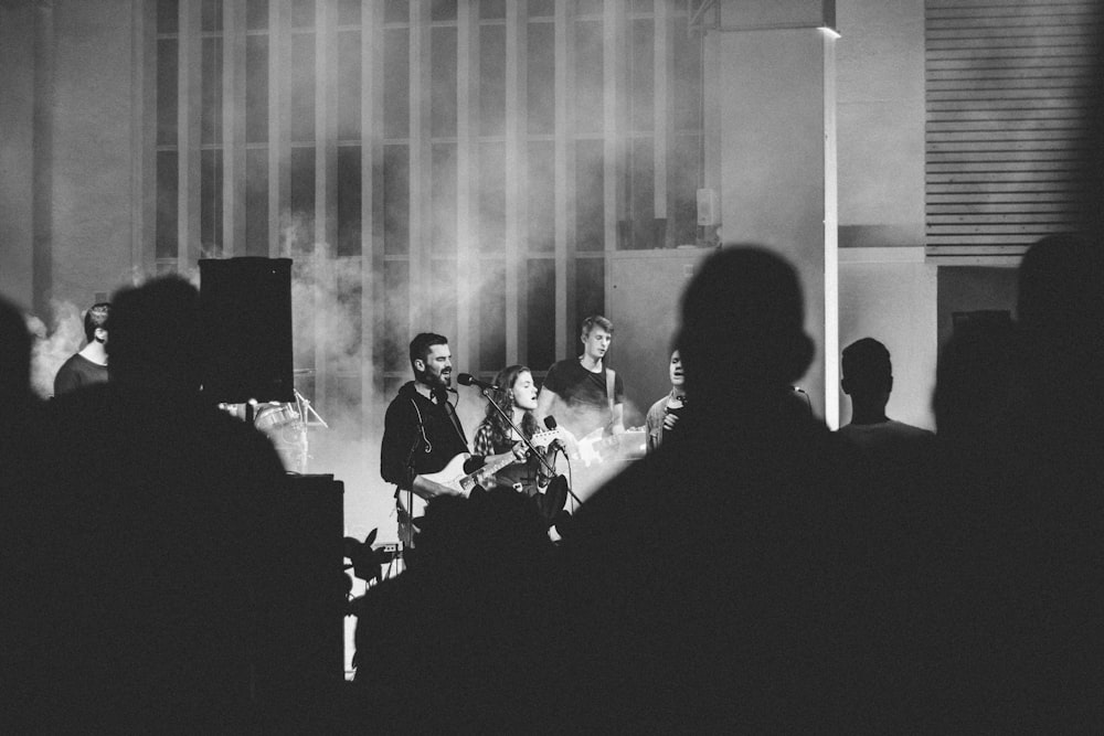 man standing while singing on stage