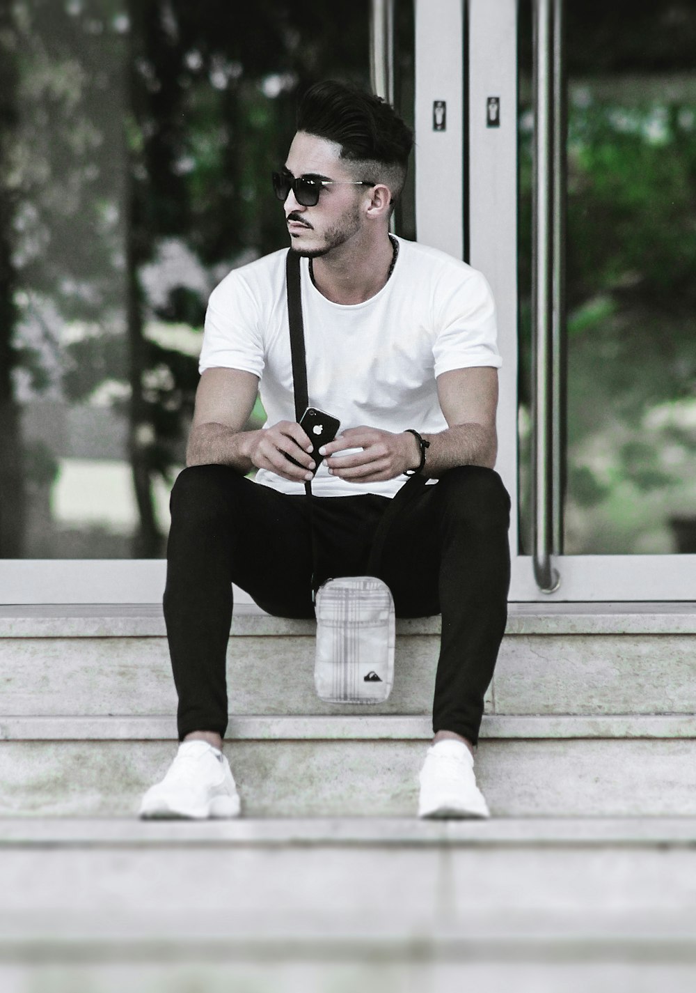 man wearing white shirt sitting on grey concrete stair case