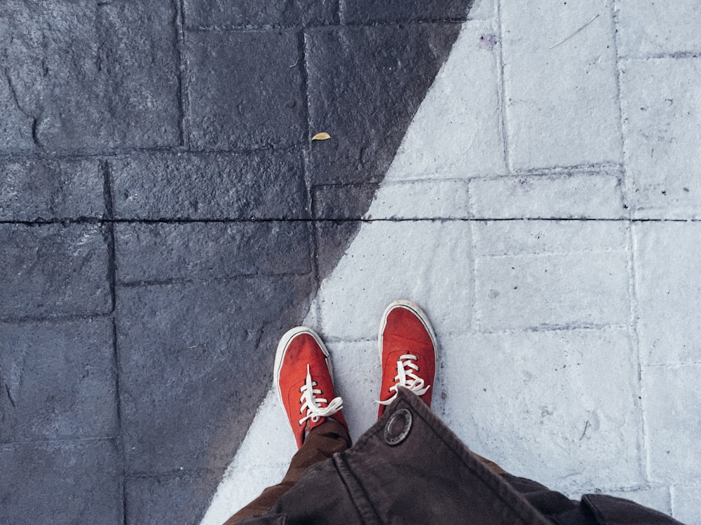 persona in piedi sul pavimento di cemento grigio