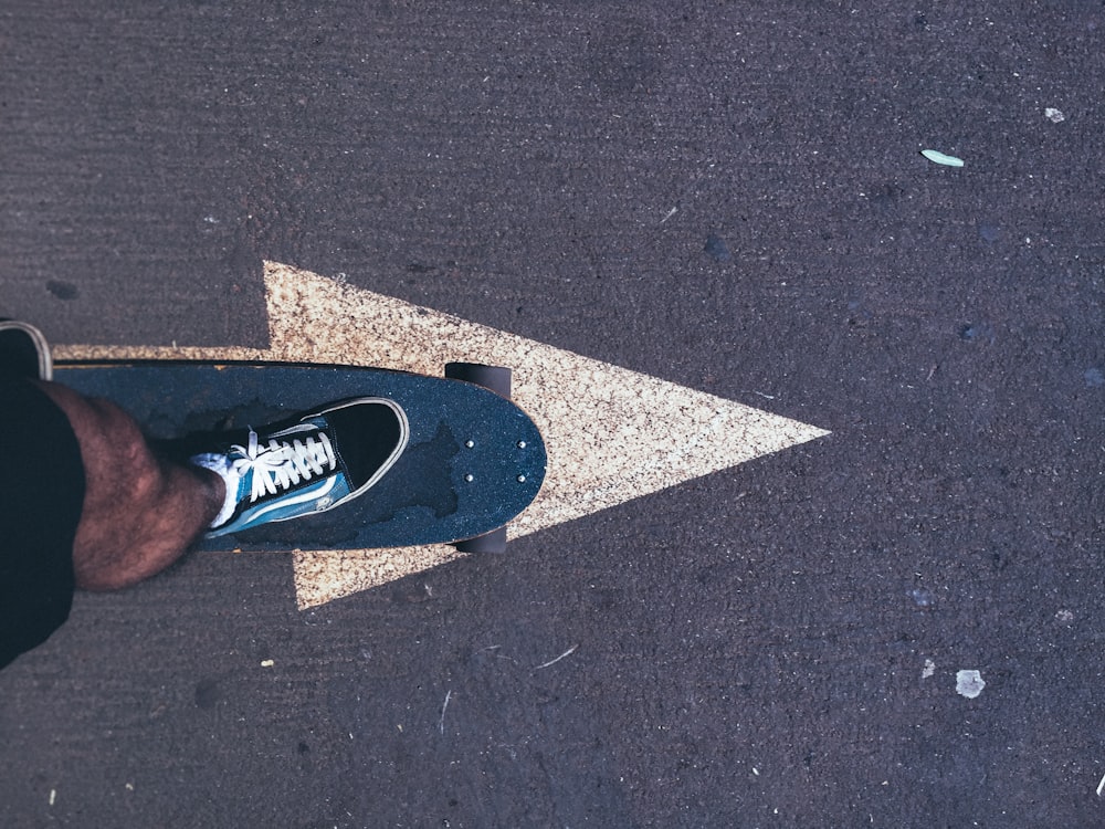 person stepping on blue skateboard outdoors