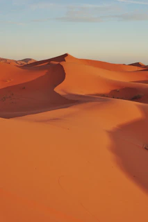 A serene sandy dune under a soft sunset sky, capturing the peaceful essence of Le Dune.