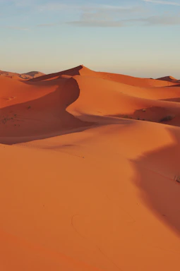 A serene sandy dune under a soft sunset sky, capturing the peaceful essence of Le Dune.