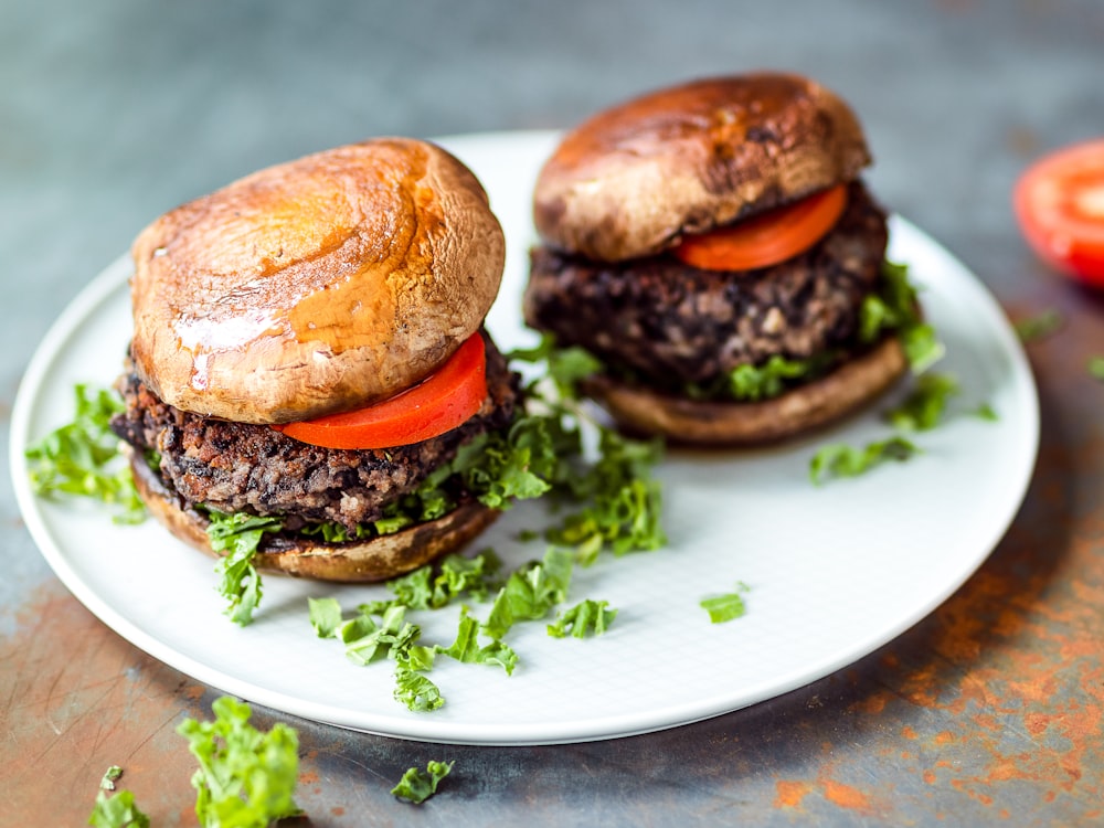 two meat burgers with garnish on saucer