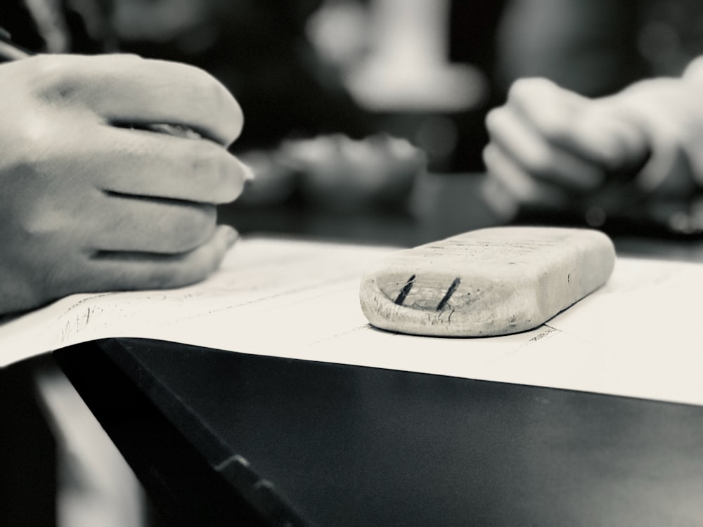 Un primer plano de una persona escribiendo en una hoja de papel