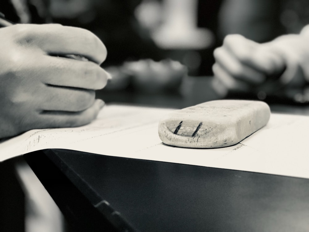 a close up of a person writing on a piece of paper