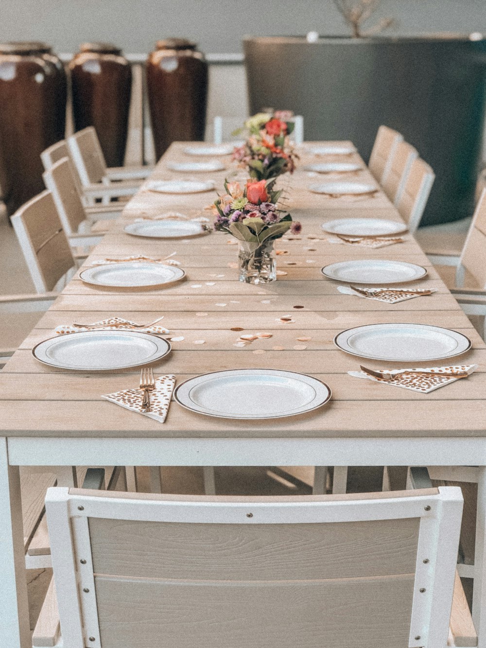 platos de cerámica blanca en mesa de comedor con sillas