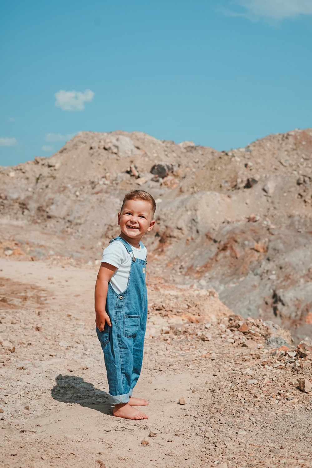 smiling boy standing near rock formations during daytime