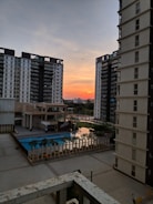 Sunset view of a completed residential complex with landscaped gardens.