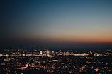 An urban skyline at dusk with twinkling city lights.