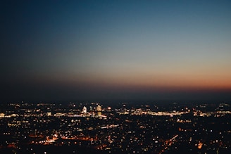 A vibrant cityscape at dusk with twinkling lights.
