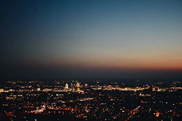 A city skyline at dusk with soft shadows and glowing lights, hinting at opportunity.
