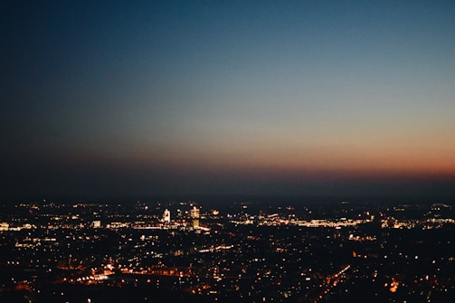 An urban skyline at dusk with twinkling city lights.