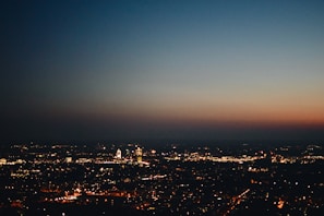 Cityscape at dusk with glowing lights symbolizing stories unfolding.