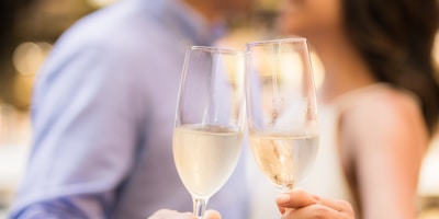 selective focus photography of couple holding cocktail glasses