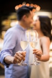selective focus photography of couple holding cocktail glasses