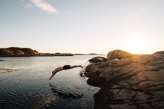 man diving on body of water in Fotö Sweden