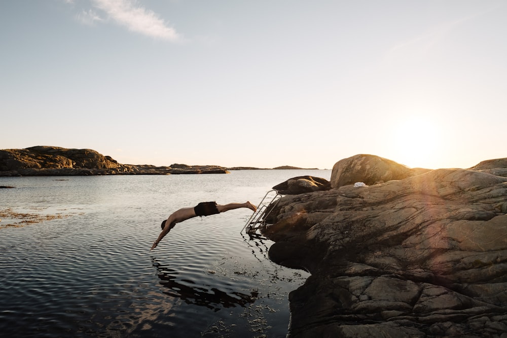 man diving on body of water