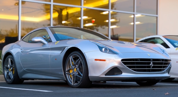 Elegant silver sports car gleaming in front of a modern building.