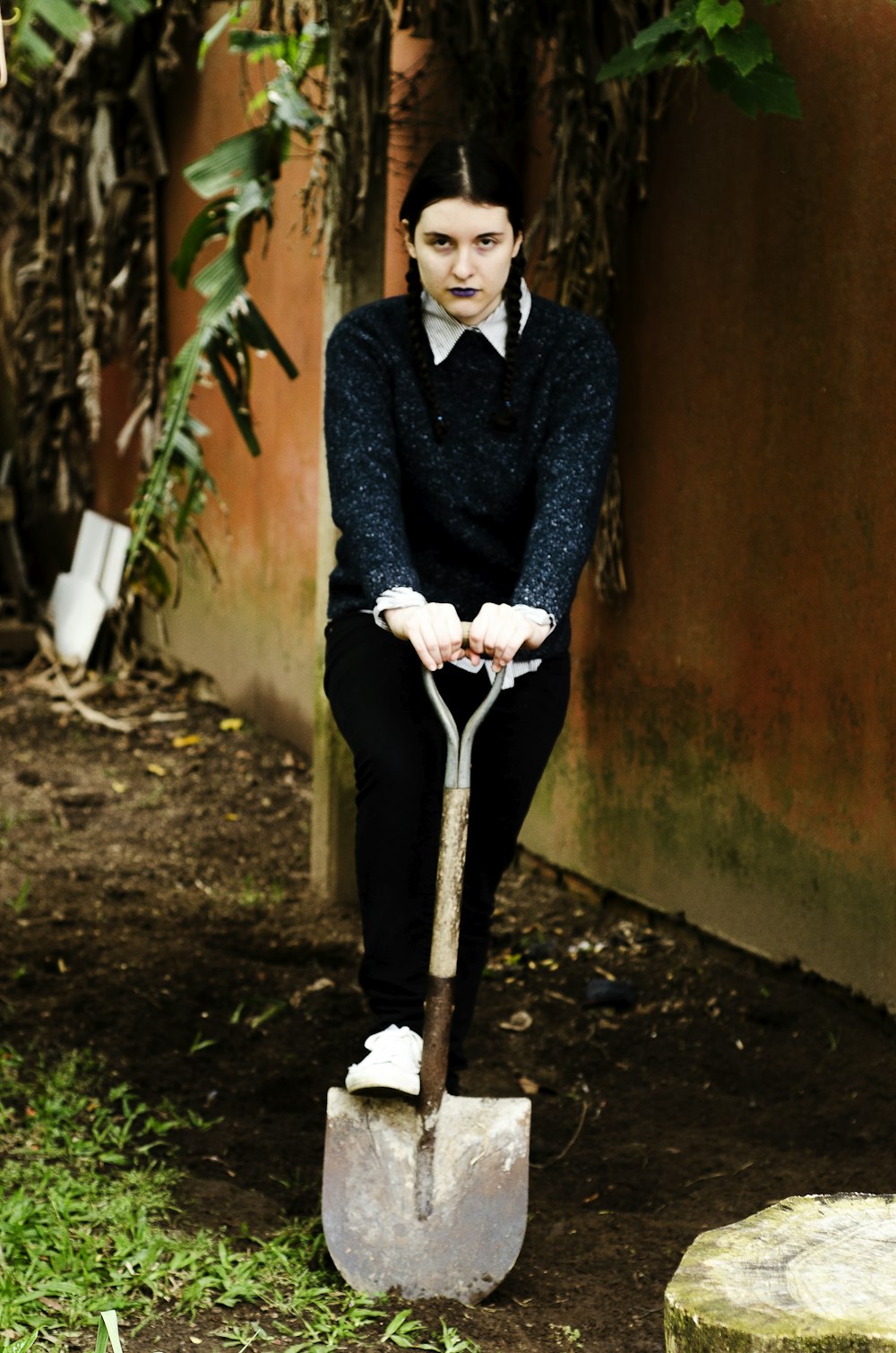 woman holding shovel near wall