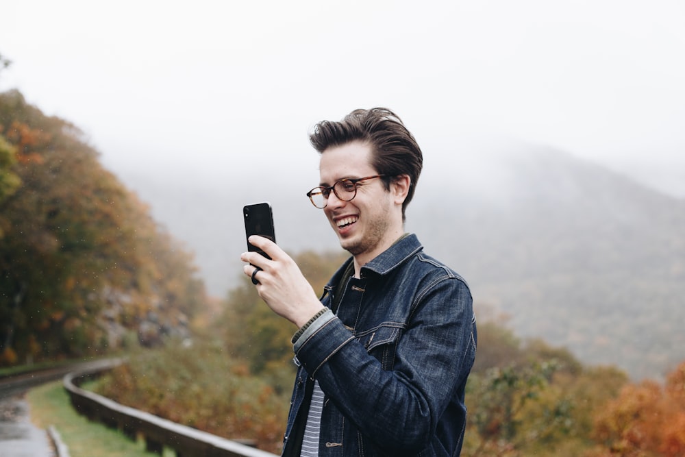 Homem sorridente olhando para seu smartphone